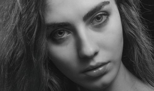 Free Grayscale close-up portrait of a woman with expressive eyes and soft lighting. Stock Photo