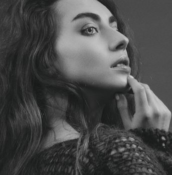 Elegant black and white portrait of a woman with long hair and a contemplative pose.