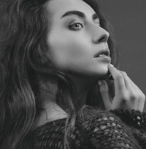 Free Elegant black and white portrait of a woman with long hair and a contemplative pose. Stock Photo