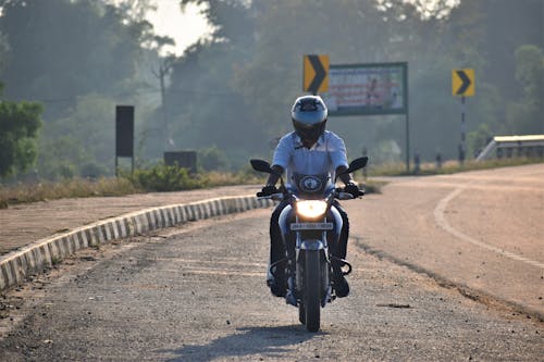 Man in Button Down Shirt Riding a Motorcycle