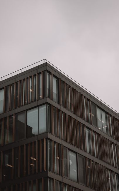 A geometric brown glass building exterior on a cloudy day in Dublin, Ireland.