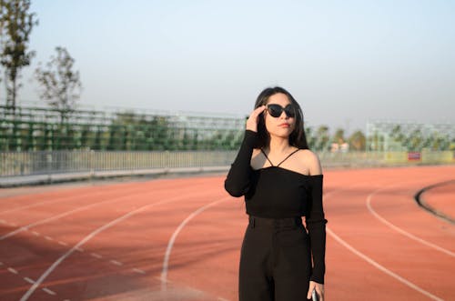 Woman in Black Dress on Athletics Track 