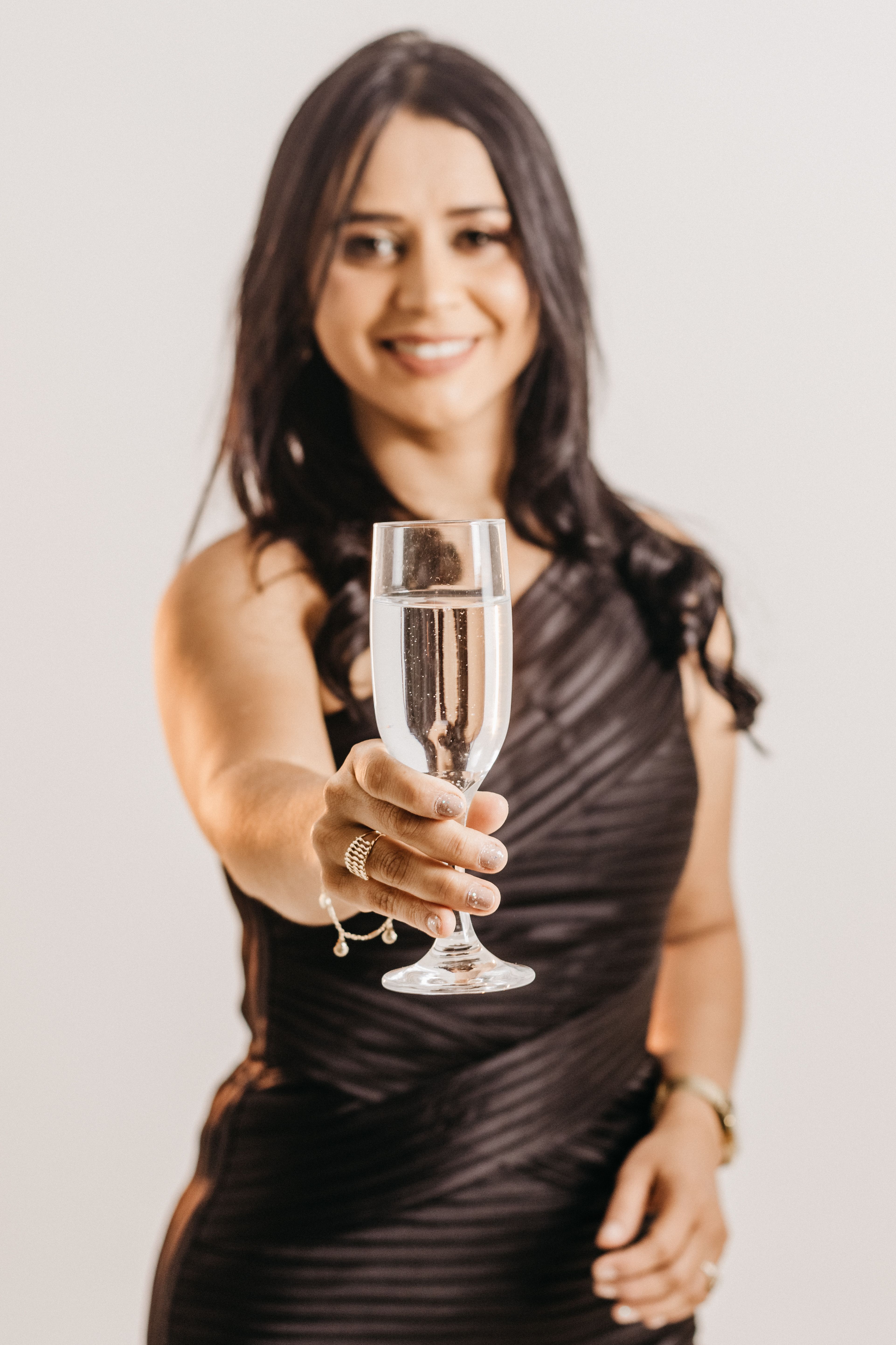 A Woman in Black Dress Holding a Champagne Glass · Free Stock Photo