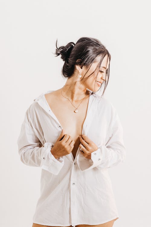 Brunette Woman Posing in a White Shirt against White Background