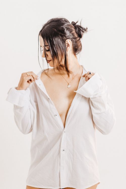 Free Caucasian woman elegantly posing in a studio with open white shirt, showcasing beauty and fashion. Stock Photo