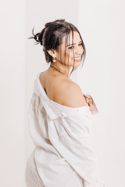 Brunette Woman Wearing a White Shirt Posing against White Background