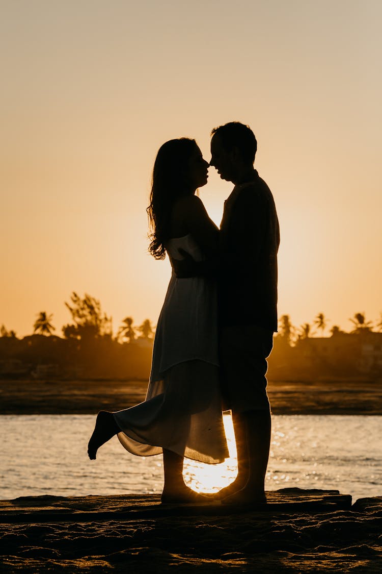 Couple Silhouette On Sunset Near River