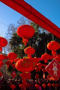 Vibrant red lanterns hang during a Chinese New Year celebration on a sunny day.