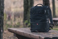 Black Backpack on Top of Wooden Table