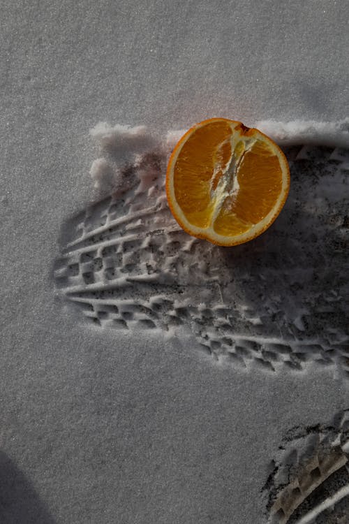 A Sliced Orange Fruit on the Snow