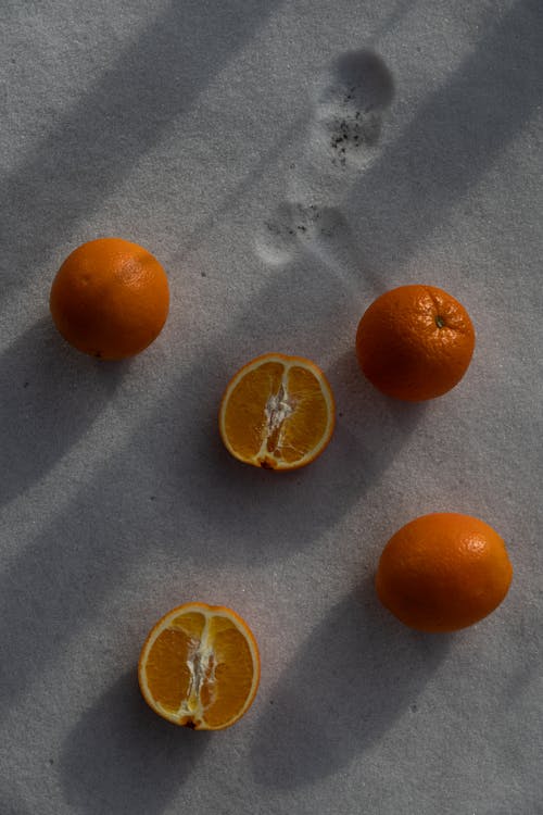 Fresh Ripe Oranges Lying on Sand