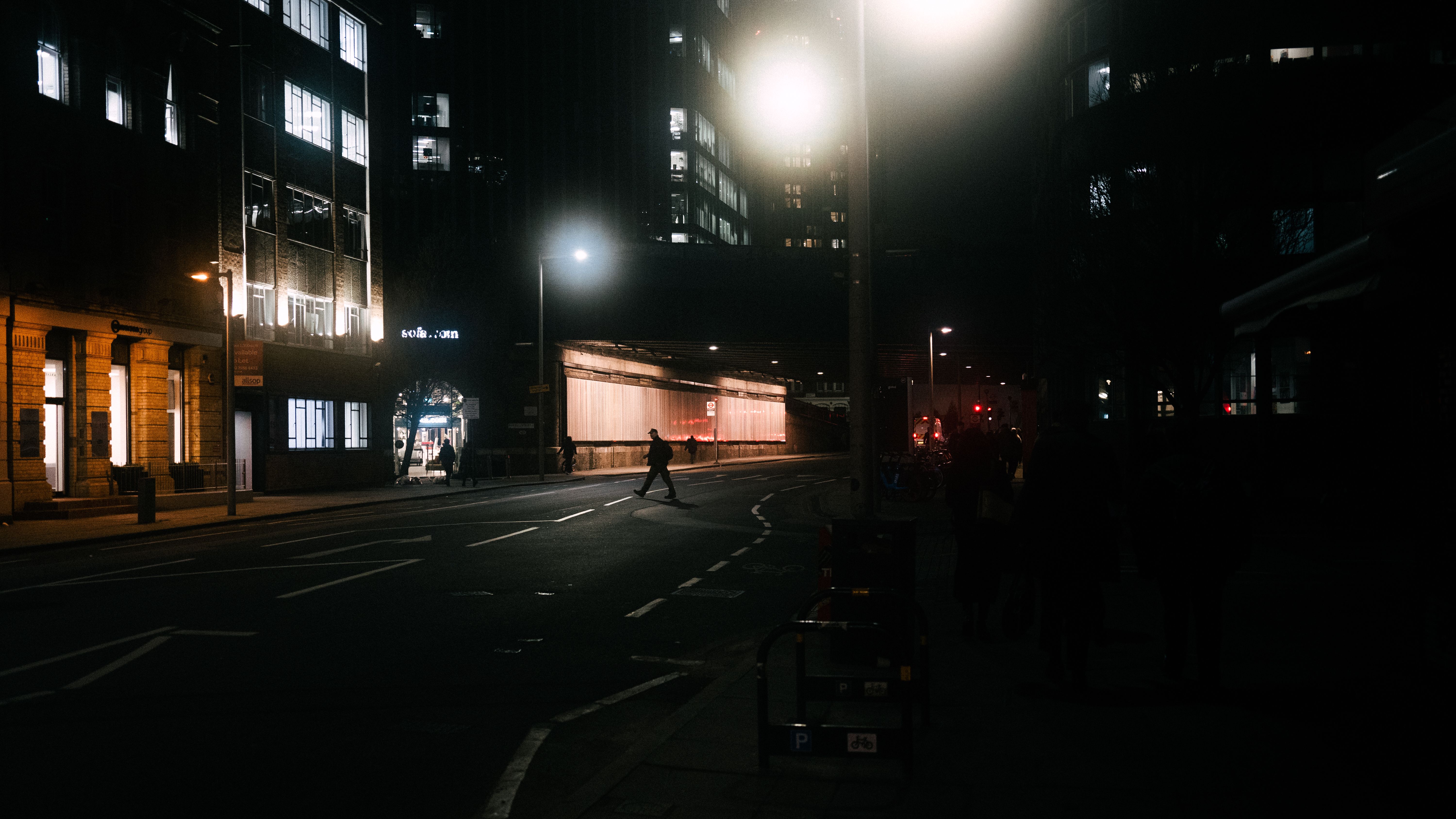 A person is walking down a street at night · Free Stock Photo