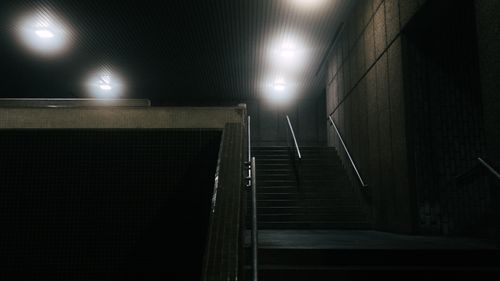 Free Dimly lit urban stairway in a subway station at night, featuring ambient lighting and modern architecture. Stock Photo