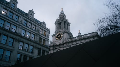 Church Tower with Clock behind Buildings in London