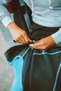 Person Holding the Zipper of Black and Blue Wetsuit