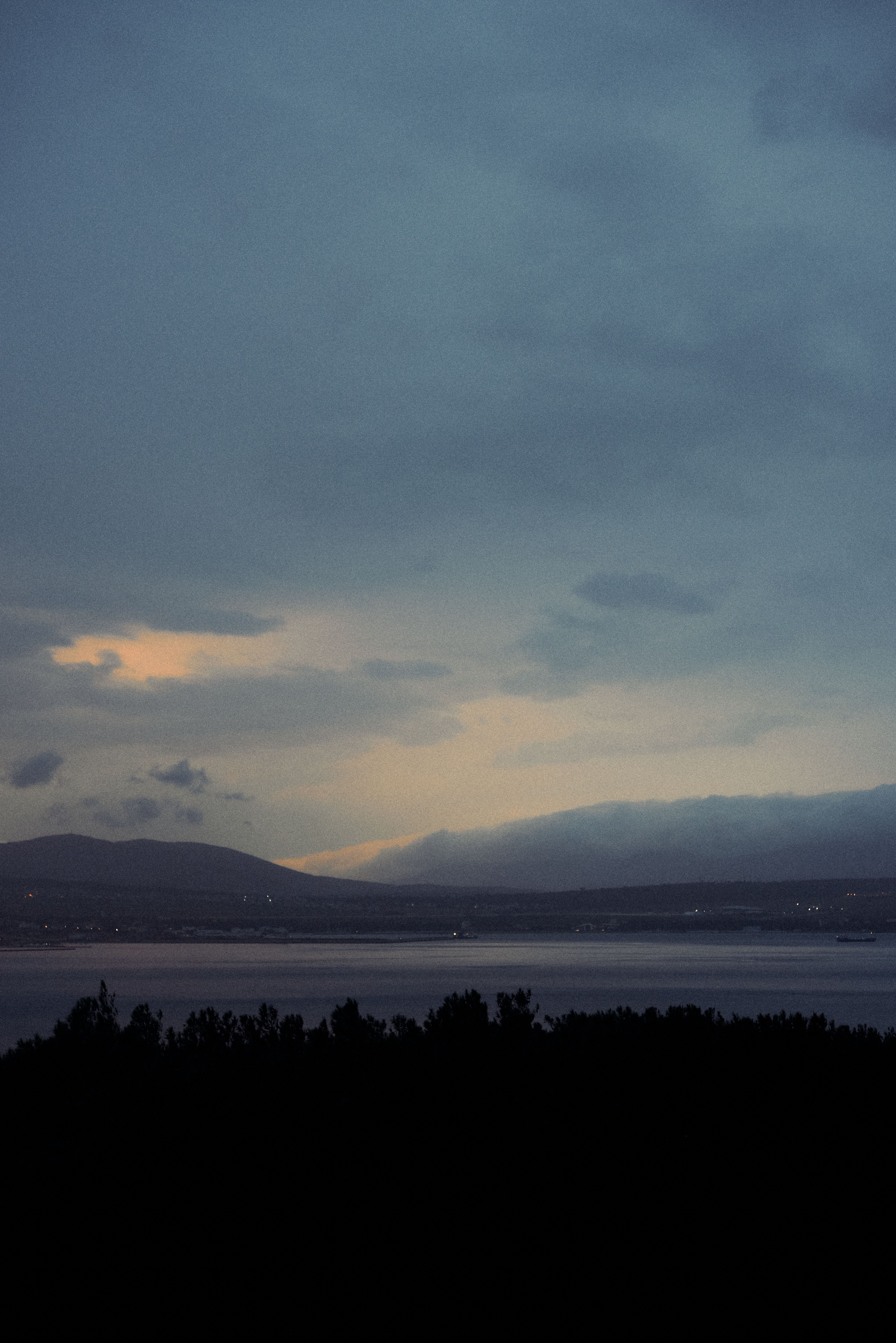Serene lake view at dusk with beautiful colors and dramatic clouds.