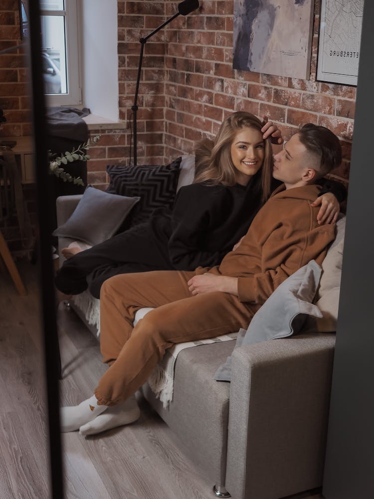 Happy Couple Sitting On Couch At Home