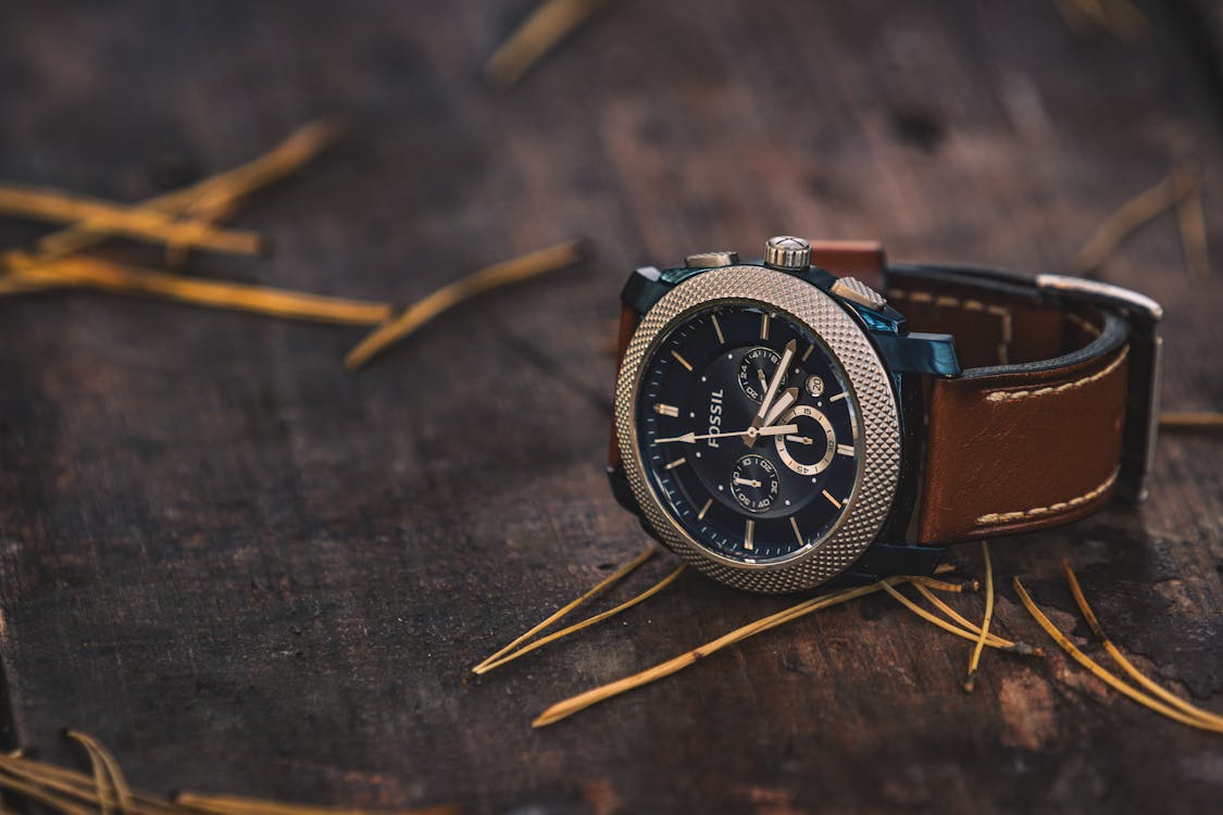 Free Round Silver Colored Fossil Chronograph Watch With Brown Leather Band On Brown Wooden Surface Stock Photo