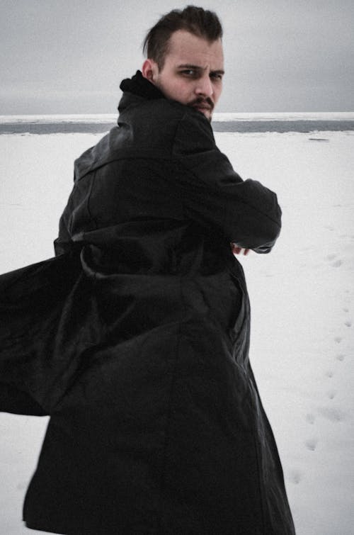 Man Posing in Black Coat in Winter