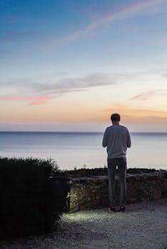 独自一人站在海边，享受宁静的日落与平静的海景