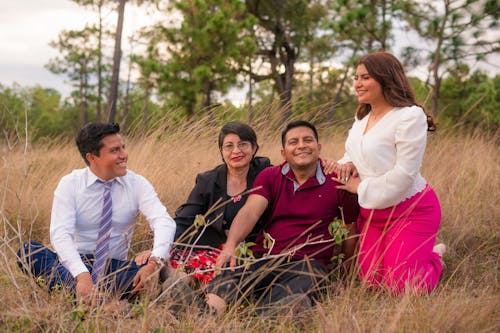 Women and Men Sitting Together on Grasses