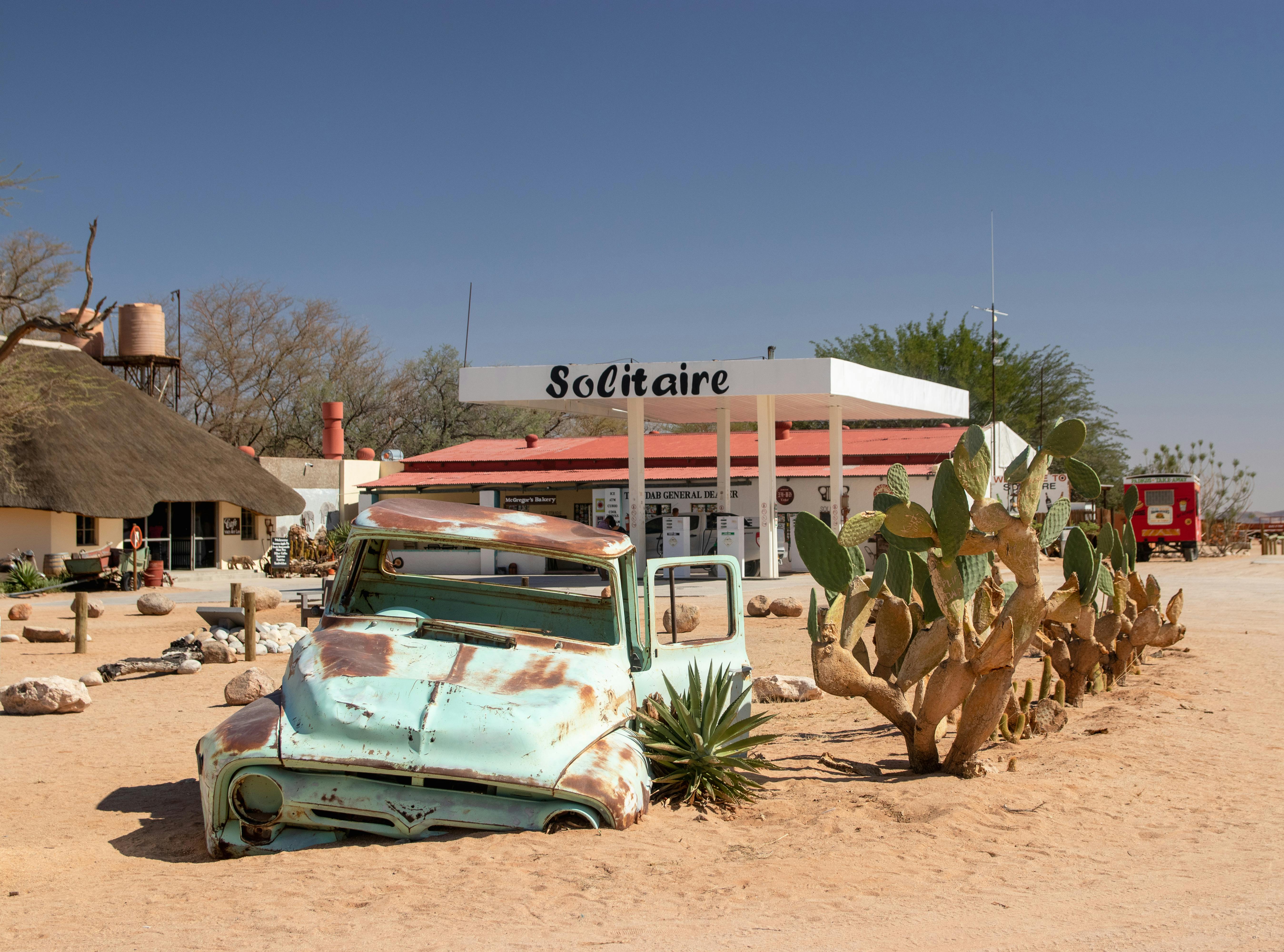 Explore the quirky charm of Solitaire, Namibia. Abandoned vehicles and desert scenery create a unique atmosphere.