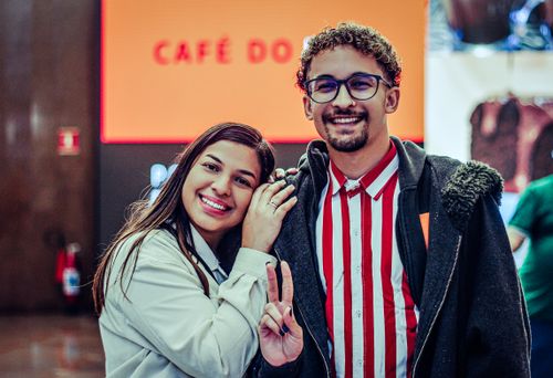 Free Happy couple smiling and posing inside a café, exuding warmth and joy. Stock Photo