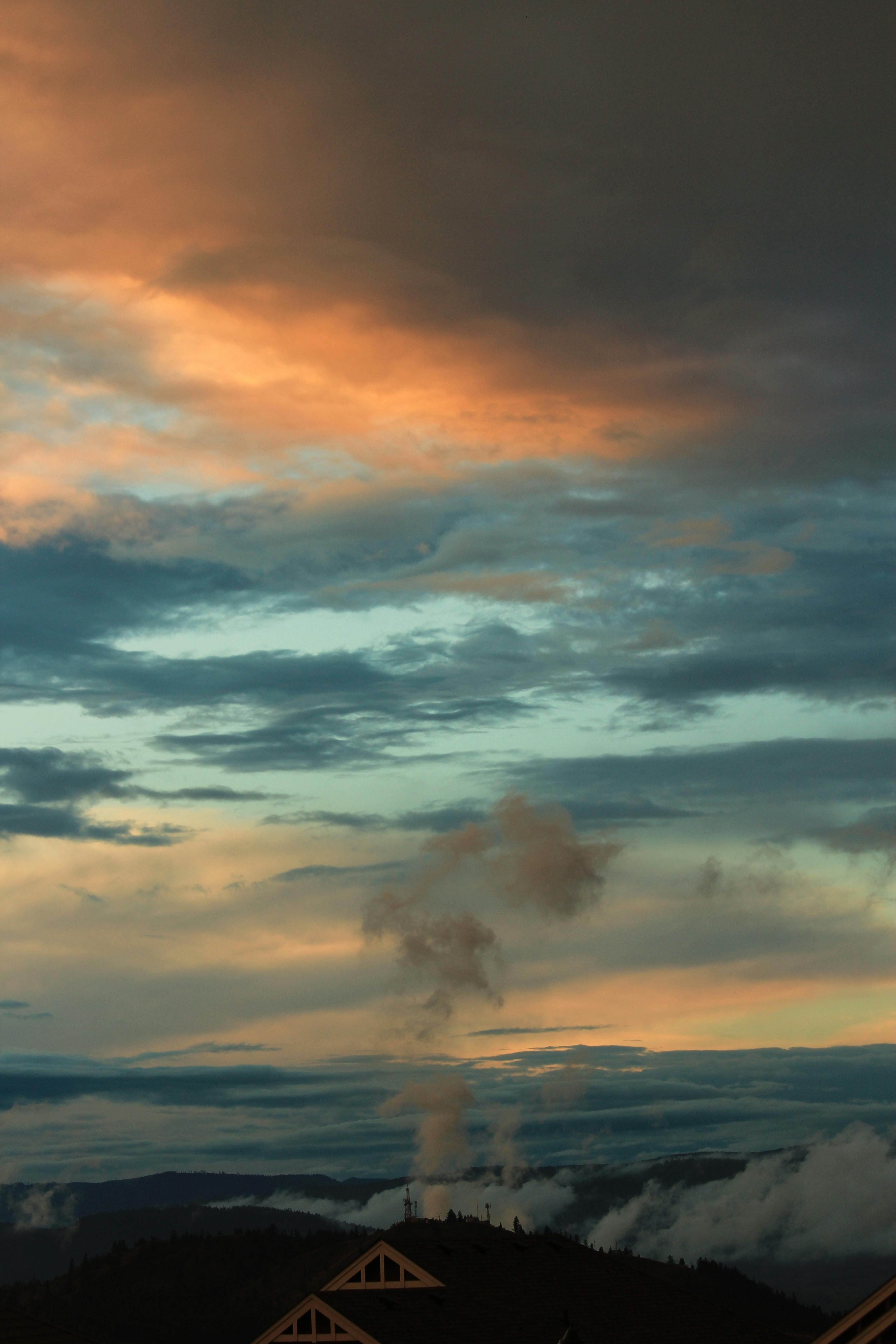 A stunning view of a dramatic winter sky filled with clouds over Pinehouse, SK at sunset.