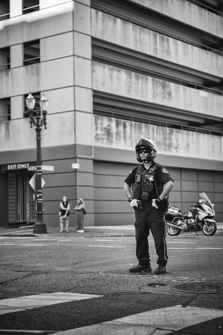 Grayscale Photo Of A Police Officer On The Road