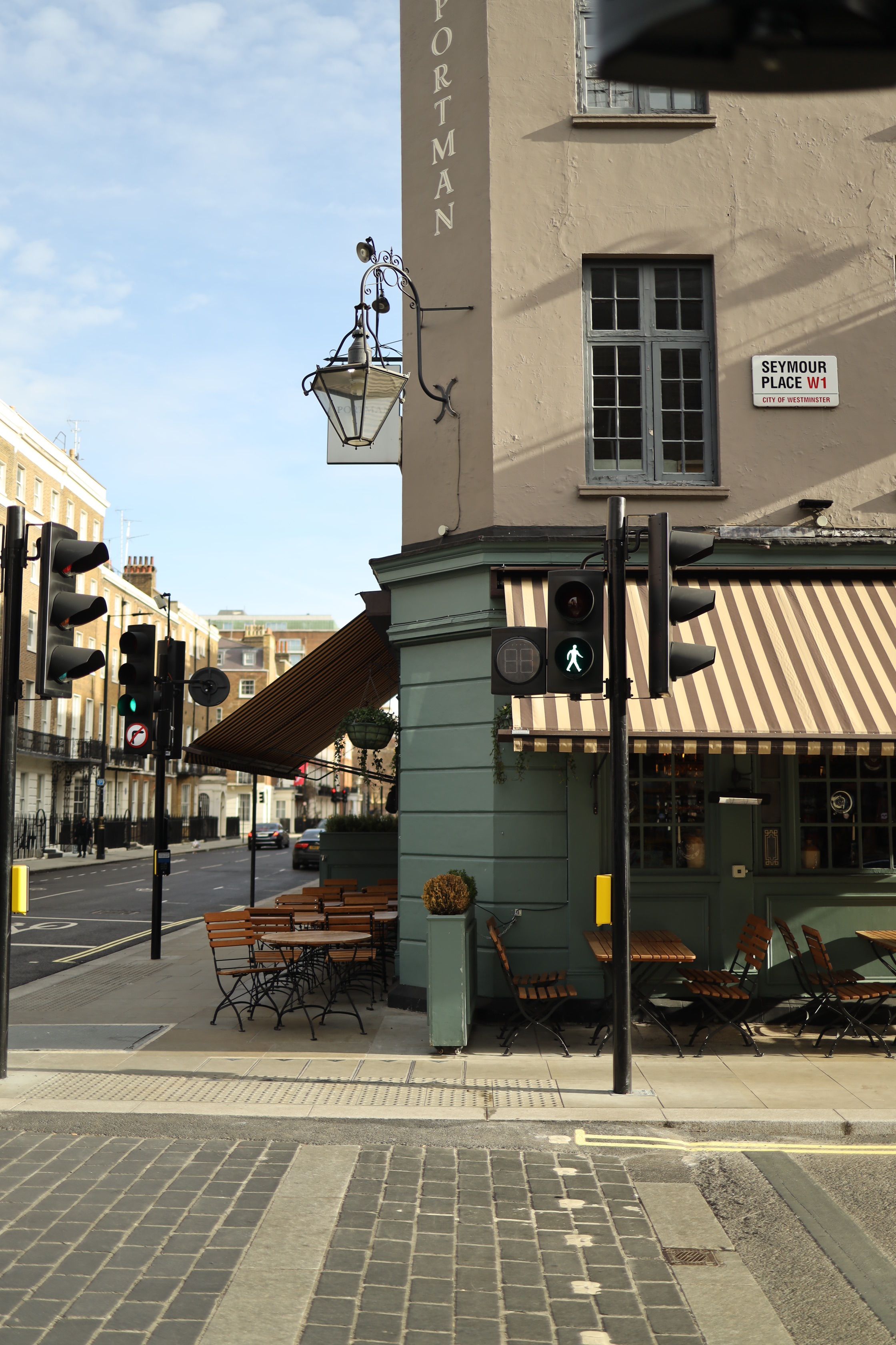 Explore a tranquil London street corner with a vintage cafe and classic architecture.