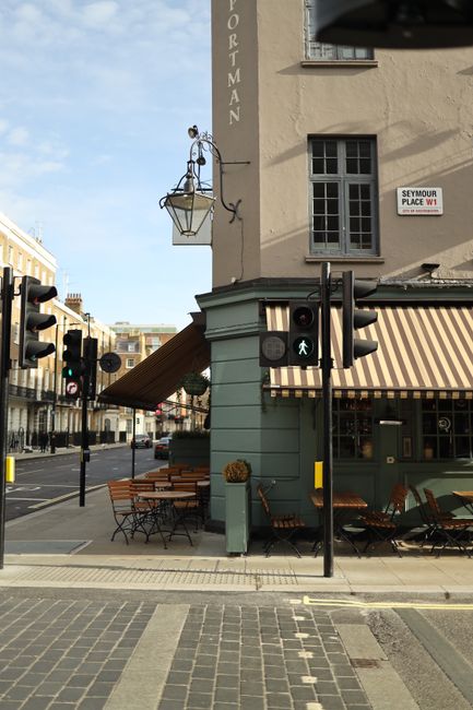 Explore a tranquil London street corner with a vintage cafe and classic architecture.