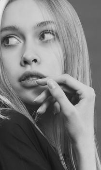 Captivating black and white portrait of a woman gazing thoughtfully, highlighting delicate features.