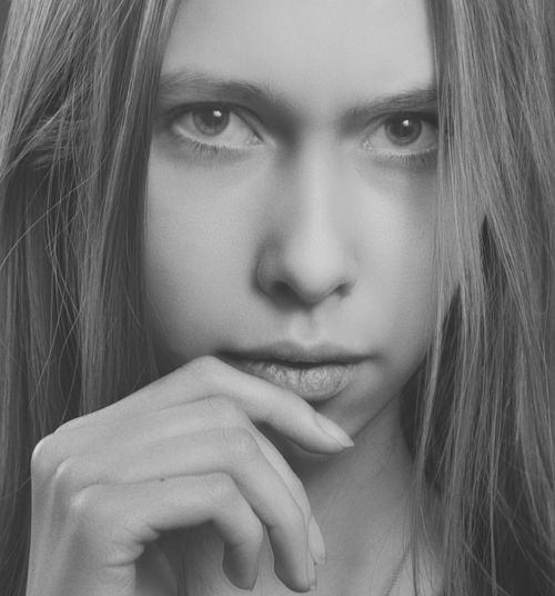 Free Intense black and white portrait of a woman with long hair and thoughtful expression. Stock Photo
