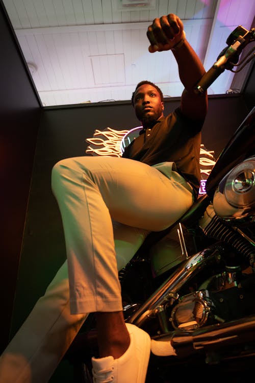 Man in Polo Shirt Posing by Motorcycle in Club