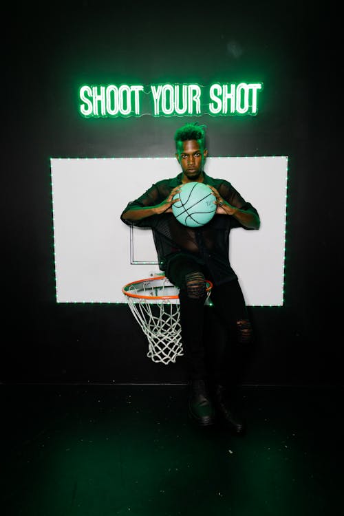 A Man Sitting on the Basketball Ring