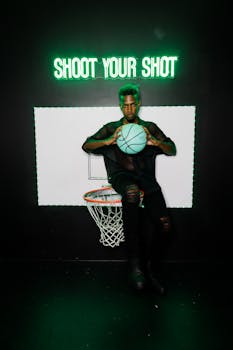 Artsy photo of a person with basketball in a neon-lit hoop scene.