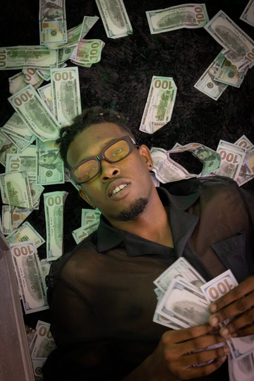 Man Lying on a Batch of Banknotes