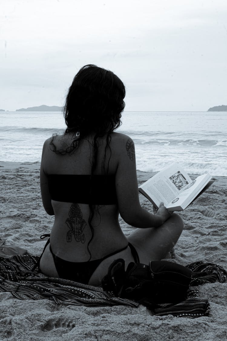 Sitting Woman Reading A Book On The Beach