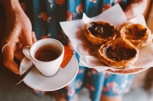 Person holding white saucer plate with teacup