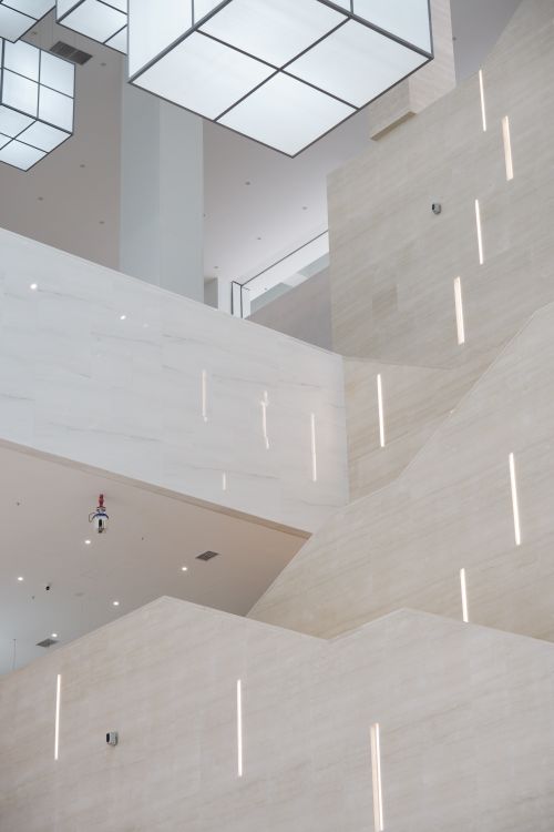 Free Elegant minimalist staircase with geometric lighting in a modern building interior. Stock Photo