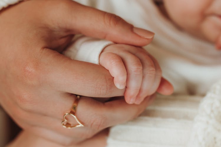 Photo Of An Adults Hand Holding A Hand Of A Baby