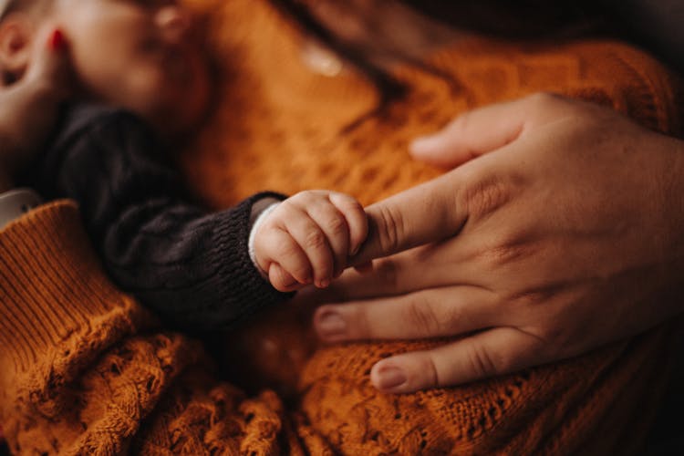 Photo Of Holding Hands Of An Adult And A Baby