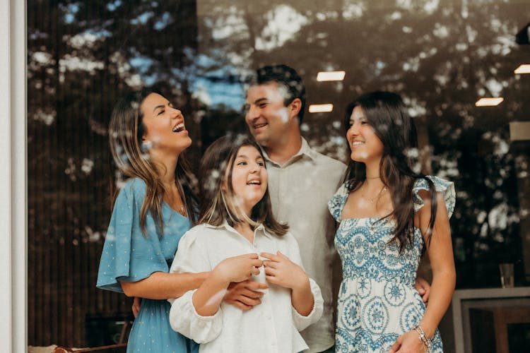 Photo Of A Smiling Family Behind The Glass