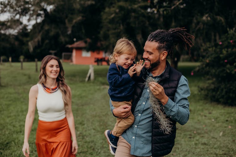 Photo Of A Woman And A Man With A Baby Boy Walking In The Countryside