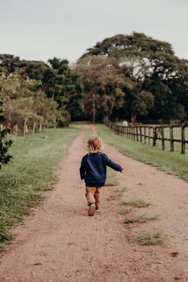 Photo Of A Little Child Walking On A Pathway