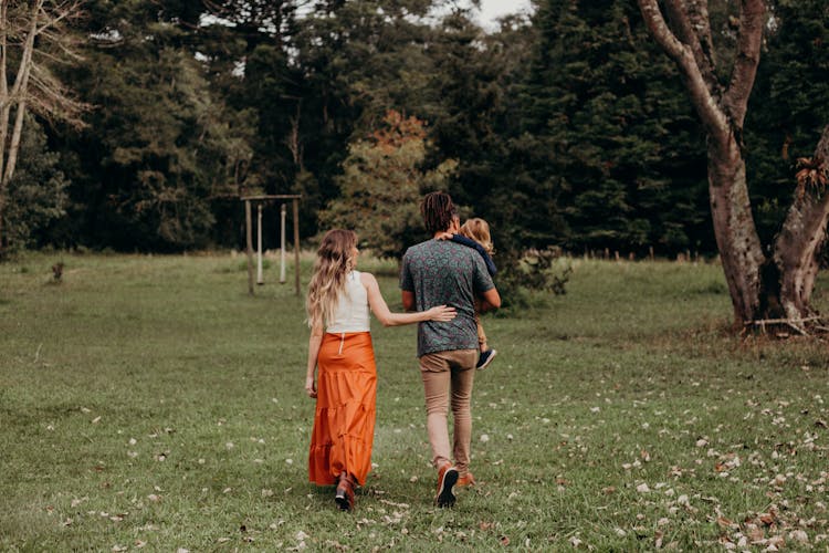 Photo Of A Couple With A Child Walking In Nature