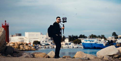 Man with Camera on a Gimbal Filming in the Harbor