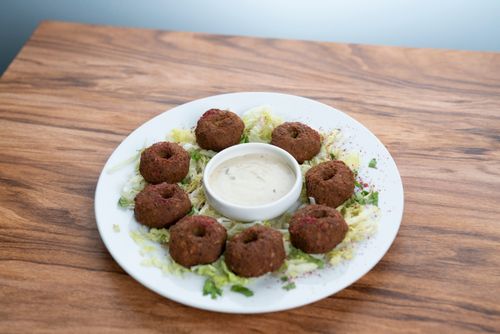 Free Close-up of falafel balls served with a creamy dipping sauce on a white plate. Stock Photo