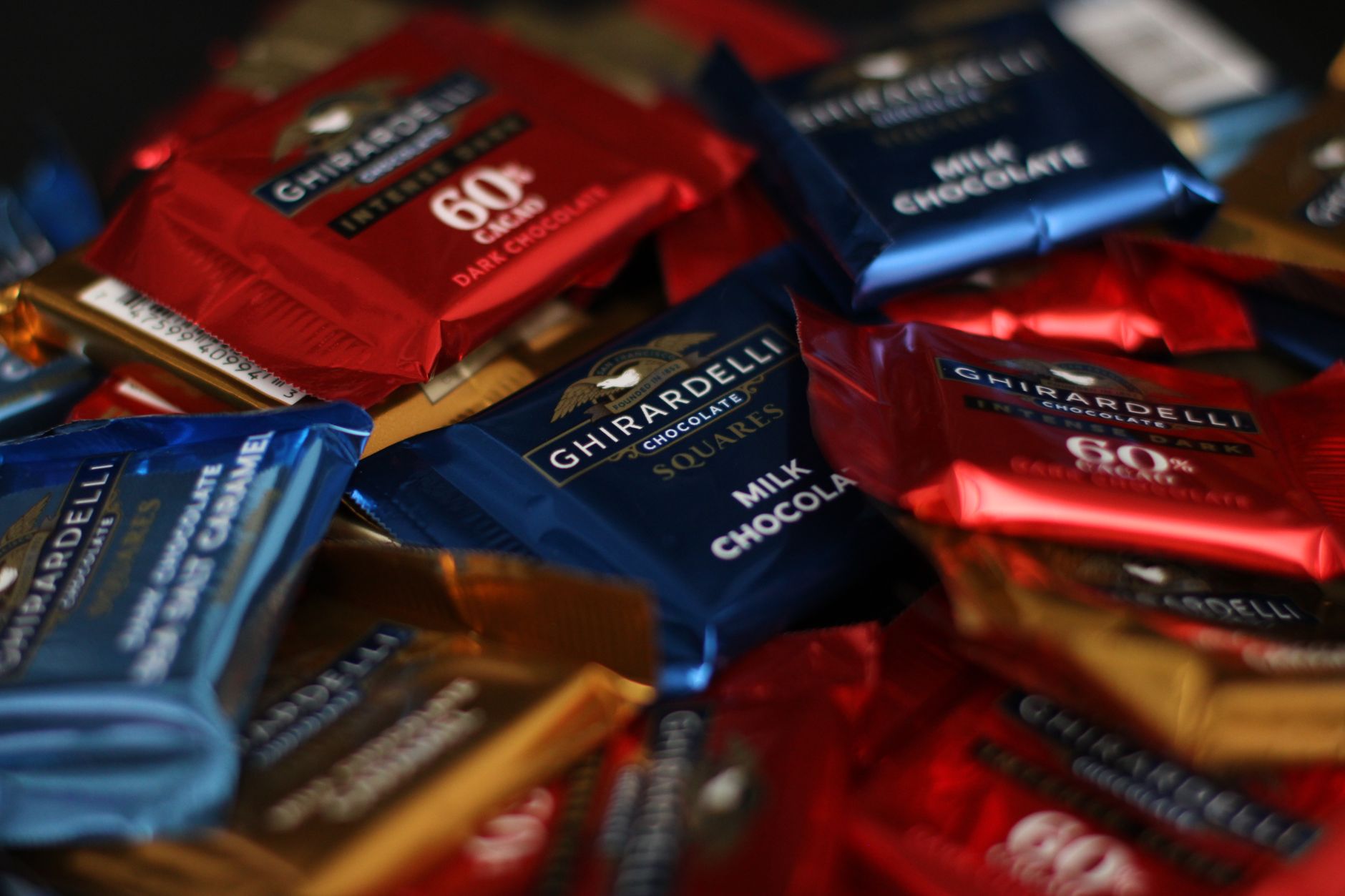 Assorted European chocolate bars and truffles displayed on a wooden table