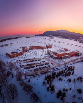 A stunning aerial sunset view of snowy landscapes and buildings in Baie-Saint-Paul, Quebec, Canada.